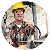 A man in a hard hat driving heaving machinery