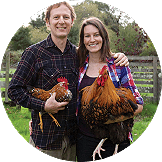 A man and woman posing for a picture while holding their pet chickens